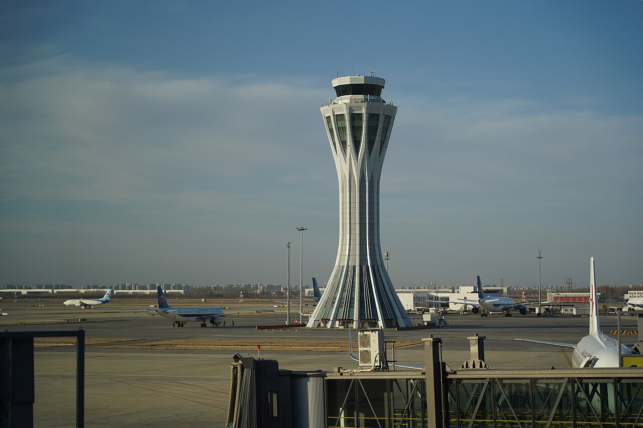 The control tower at Beijing Daxing International Airport with airliners parked on the apron